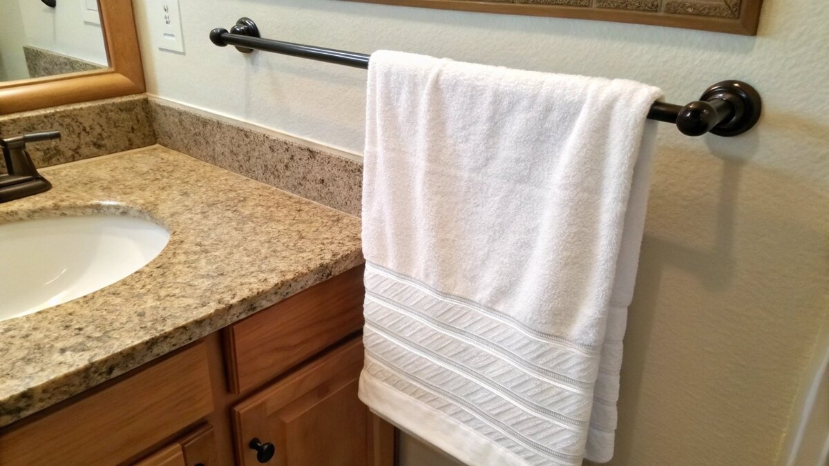 A hand towel hanging from a bar, showing ample clearance from the countertop below