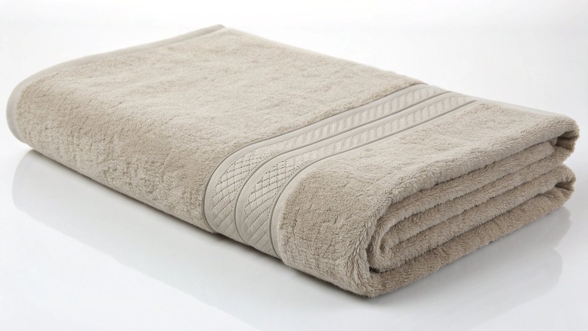 A standard-sized hand towel folded neatly on a white countertop