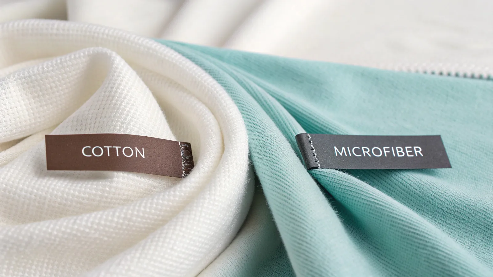 A stack of clean, folded white and gray face towels on a wooden surface.